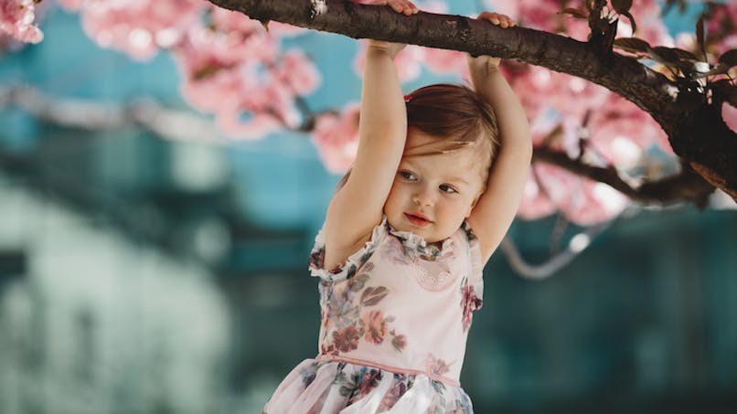 fillette tenant une branche d'arbre fleuri