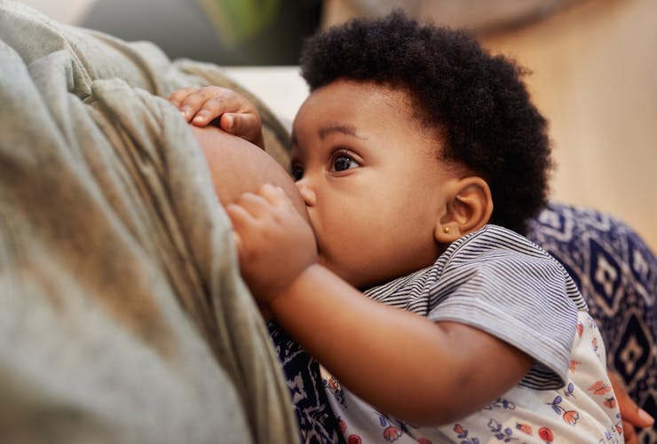 Une femme allaite son bébé, une pratique que l'OMS recommande de poursuivre malgré une infection au Covid-19