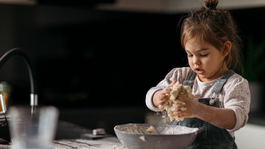 Gluten : une petite fille cuisine une pâte à tarte