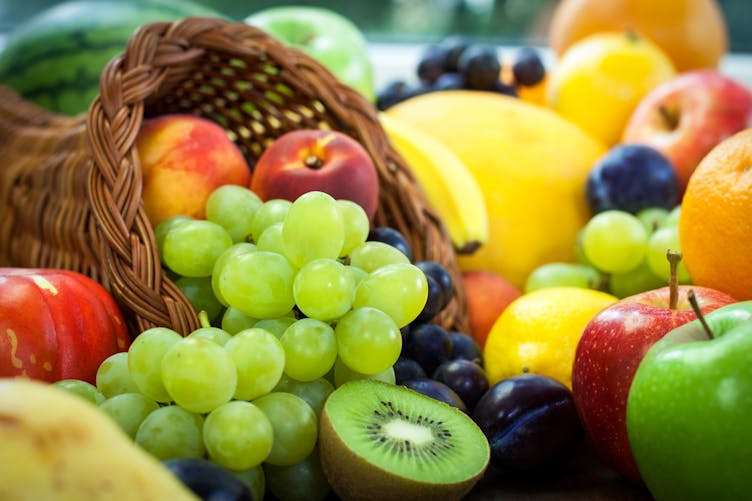Panier de fruits avec raisin, pomme, kiwi, orange, banane