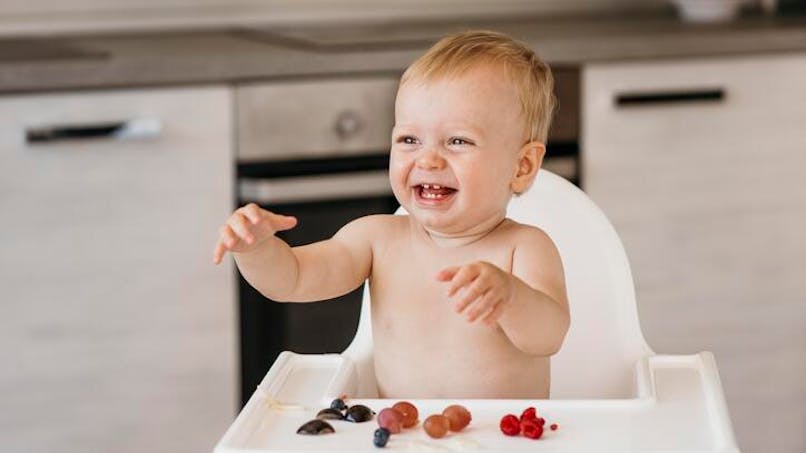 bébé joue avec des fruits