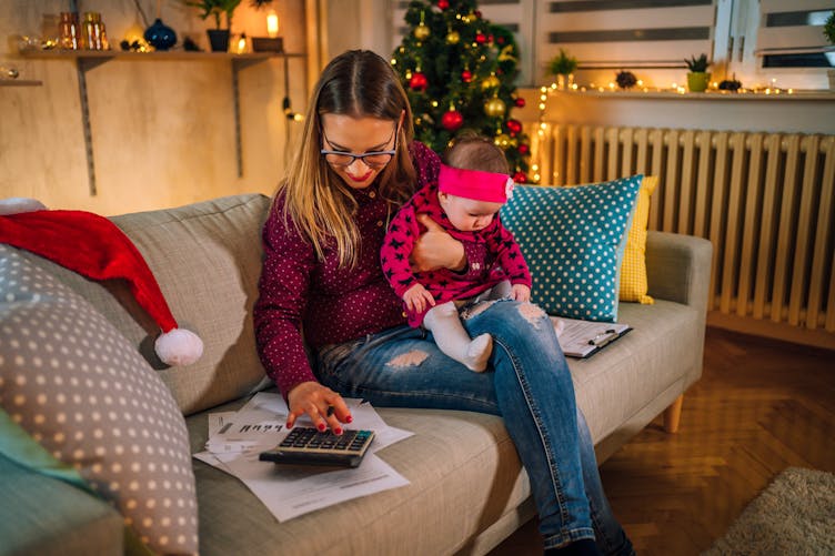 Une jeune mère avec son bébé calcule son budget avec Noël