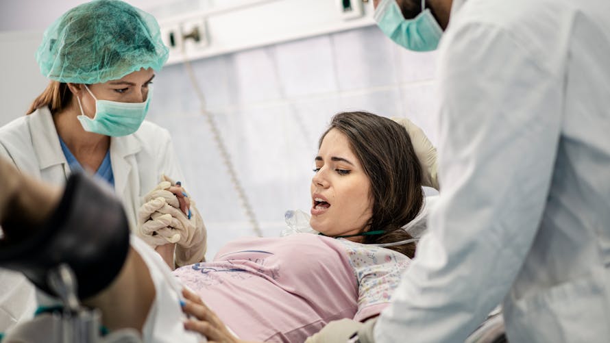 Une femme est accompagnée par des soignants pendant son accouchement