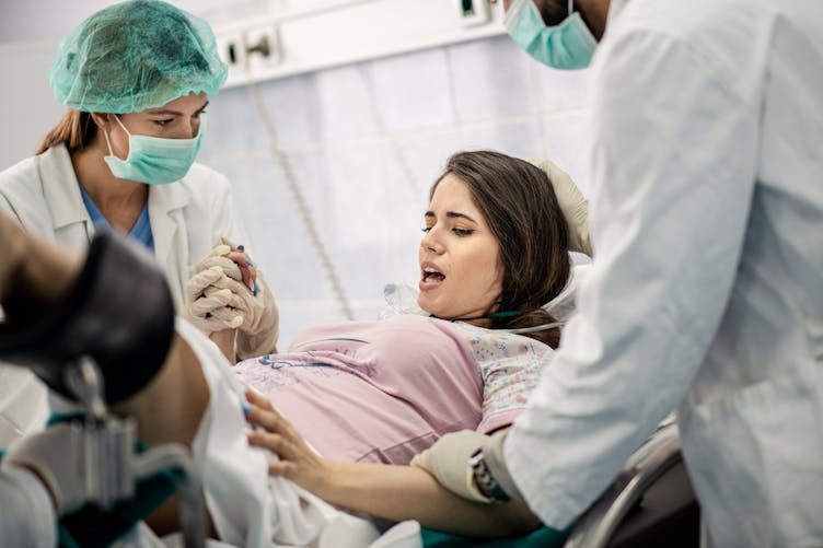 Une femme est accompagnée par des soignants pendant son accouchement