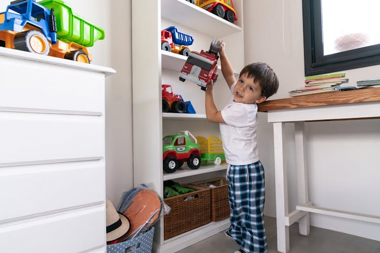 enfant attrapant un jouet dans sa chambre