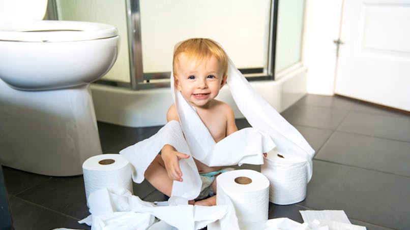 bébé joue avec du papier toilette