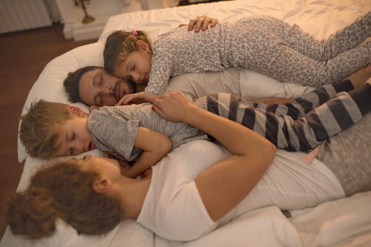 Des parents dorment avec leurs enfants