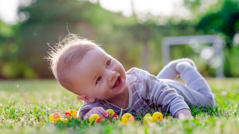 bébé tout sourire dans l'herbe