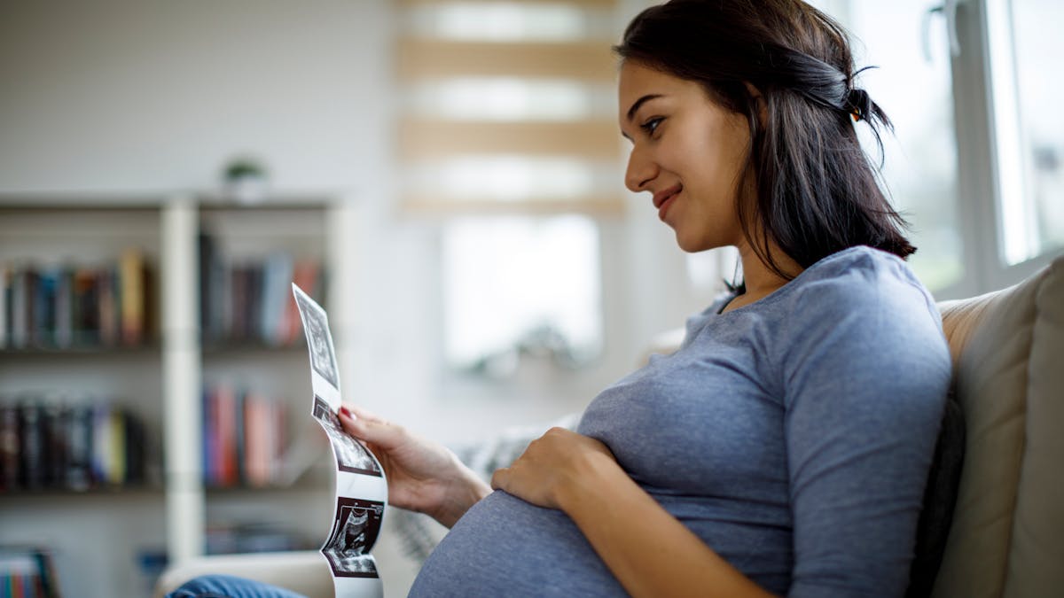 Une femme enceinte, sur le point d'accoucher, regarde des échographies.