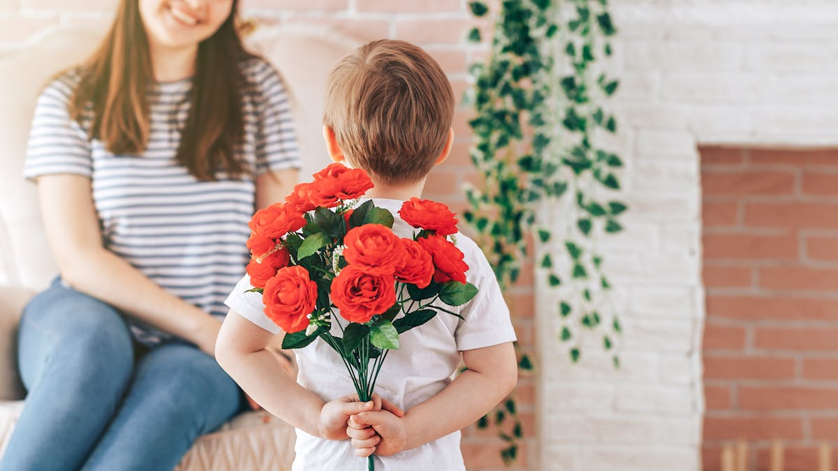 enfant offrant des fleurs à sa mère pour la fête des mères