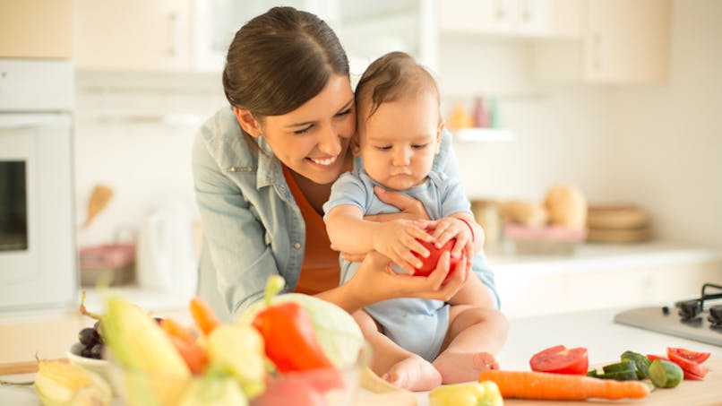 bébé touche les fruits dans cuisine