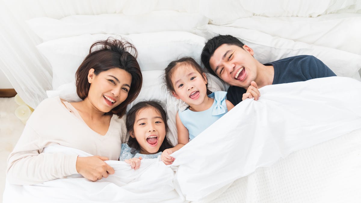 Une famille au lit avec leurs enfants.