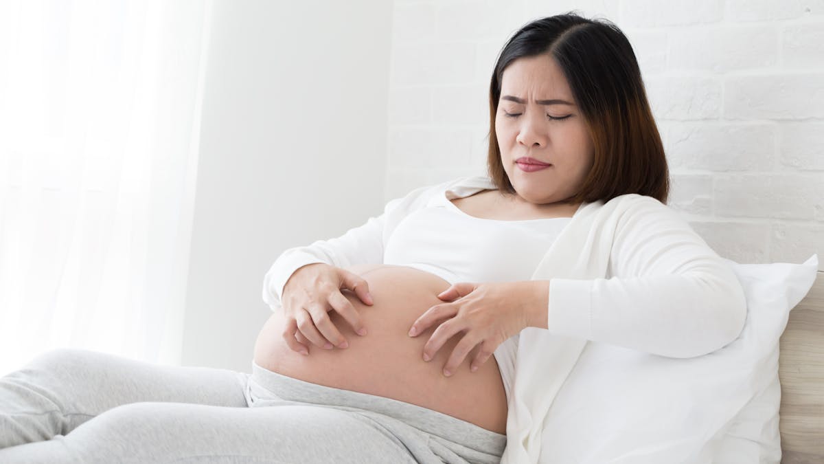 Une femme enceinte se gratte sur le ventre