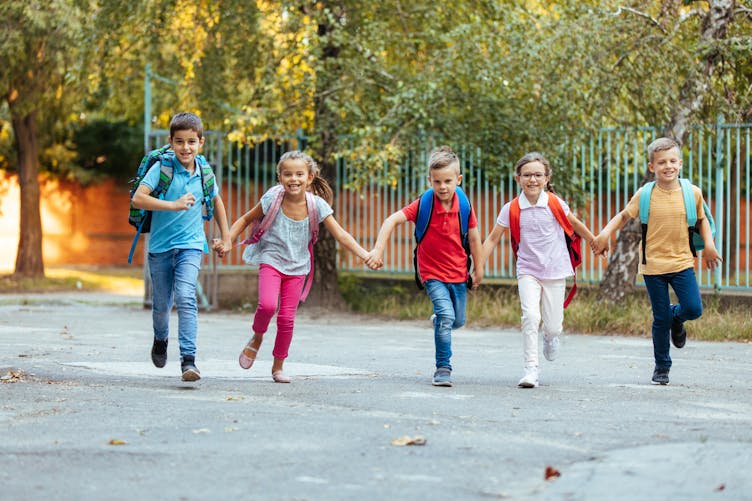 Des enfants courent dans une cour d'école
