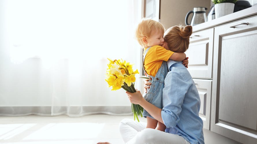 bébé offre des fleurs à maman