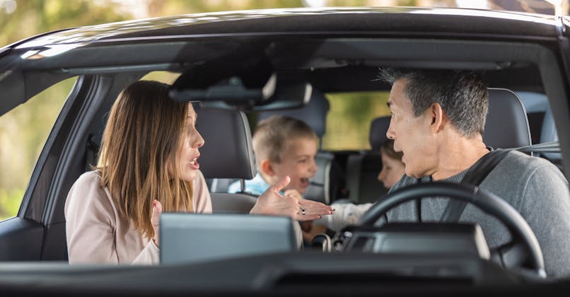Des parents essaient de calmer les colères de leurs enfants en voiture.