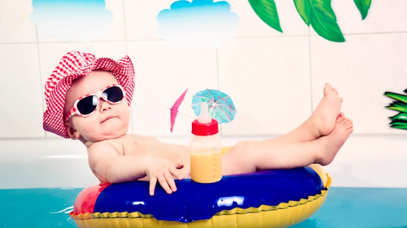 bébé sur bouée avec lunettes de soleil, et biberon