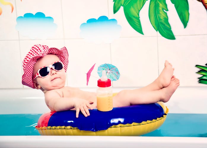 bébé sur bouée avec lunettes de soleil, et biberon