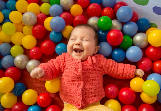 bébé dans un bain de boules colorées