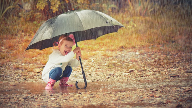 fillette sous la pluie sous un parapluie
