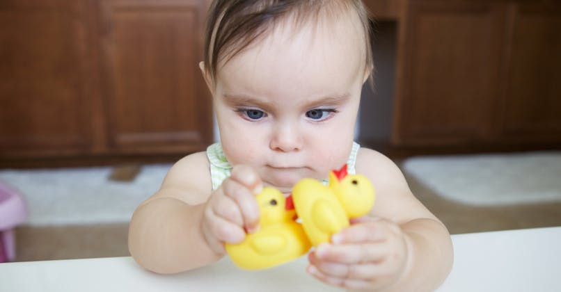 Un bébé louche en jouant avec des canards