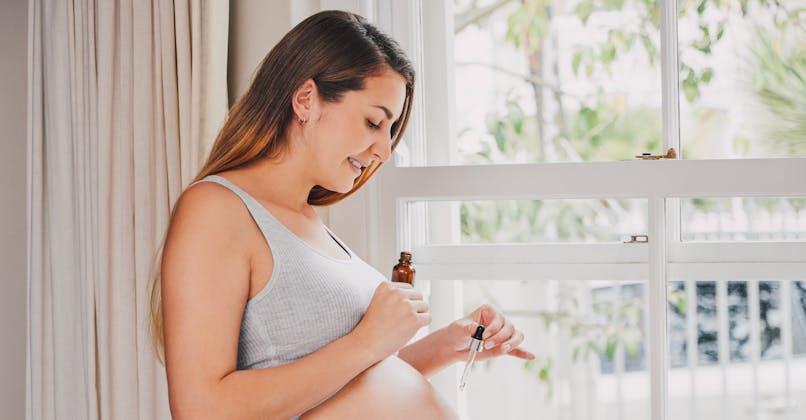 Une femme enceinte utilise des huiles essentielles.