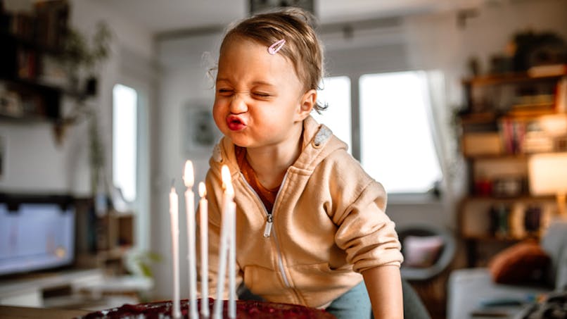 bébé souffle les bougies d'un gateau