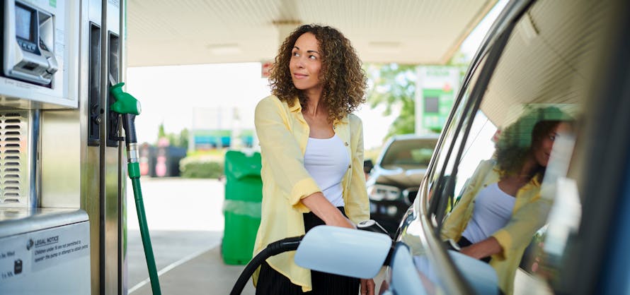Une femme met de l'essence dans sa voiture.