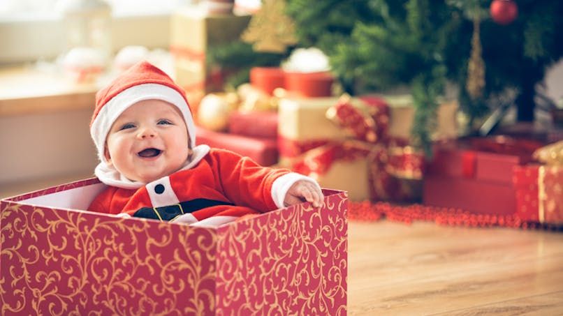 bébé dans carton au pied du sapin de Noel
