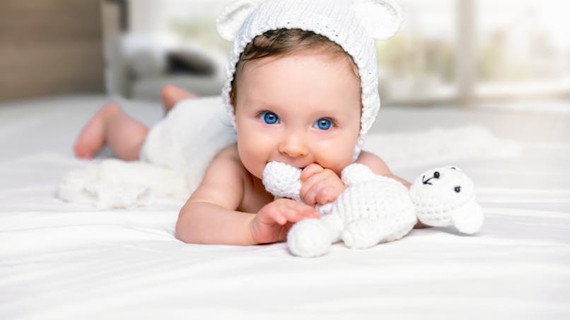 bébé aux yeux bleus avec doudou