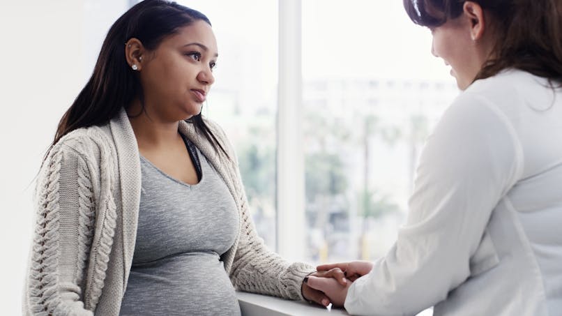 Une médecin rassure une femme enceinte.