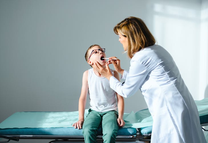 médecin regardant la gorge d'un enfant