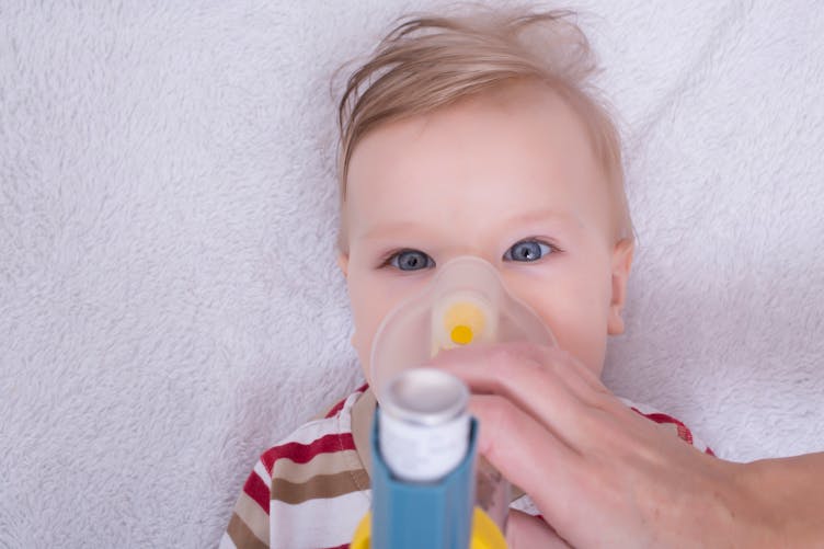 Un enfant respire avec un appareil pour soulager une bronchiolite.
