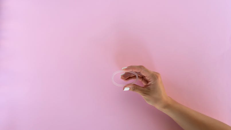 Une main de femme qui tient un anneau vaginal. 