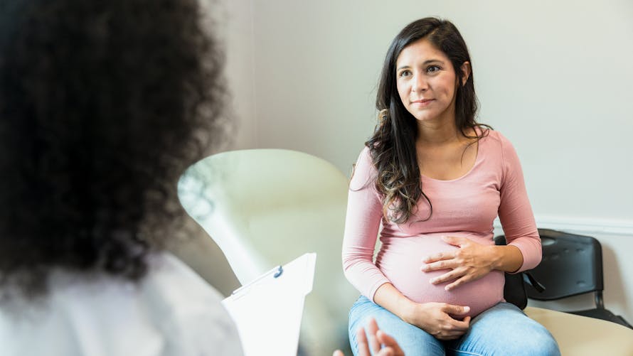 Une femme enceinte écoute une médecin.