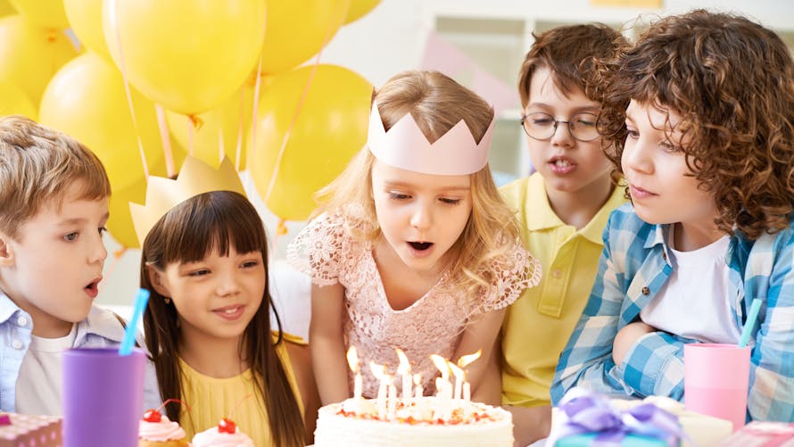 Des enfants devant un gâteau d'anniversaire