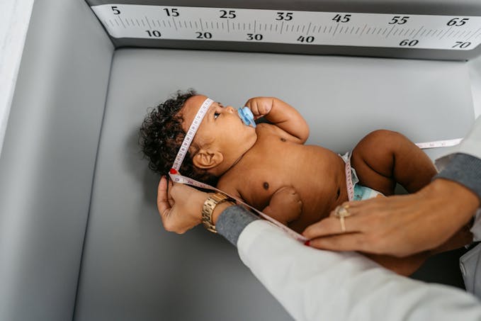 bébé est mesuré par le pédiatre