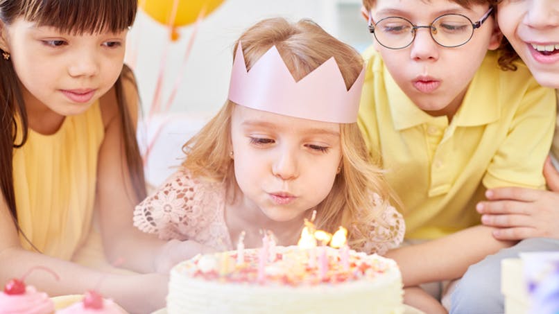 petite fille qui souffle bougies gâteau anniversaire