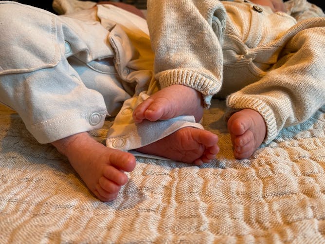Pieds de nouveaux-nés couchés l'un à côté de l'autre