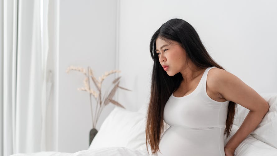 Une femme enceinte semble souffrir de douleurs au dos.
