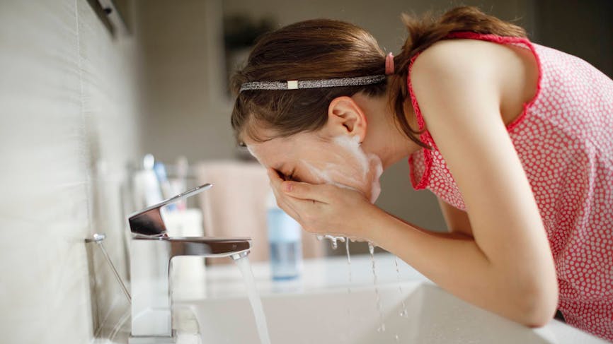 jeune fille se lavant le visage 
