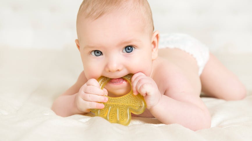 Un bébé mâchouille un anneau de dentition réfrigéré