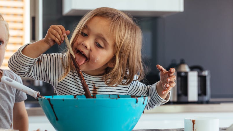 petite fille mangeant du chocolat en cuisine