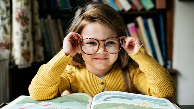 petite avec des lunettes devant un livre