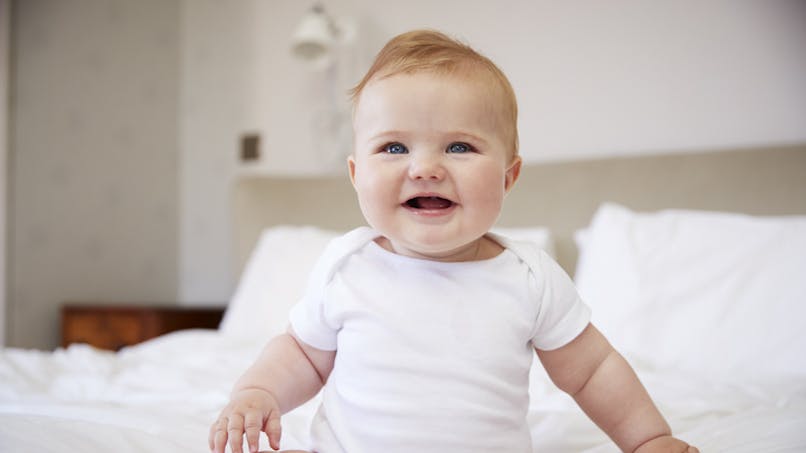bébé heureux habillé en blanc