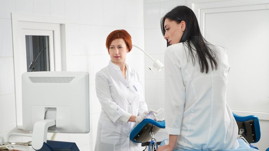 Une femme discute avec une gynécologue avant une échographie