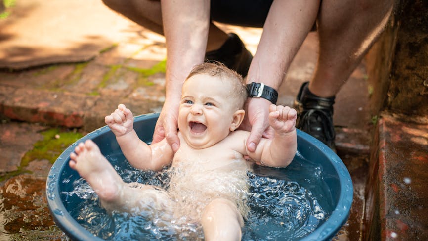 Un bébé s'amuse dans une petite piscine.