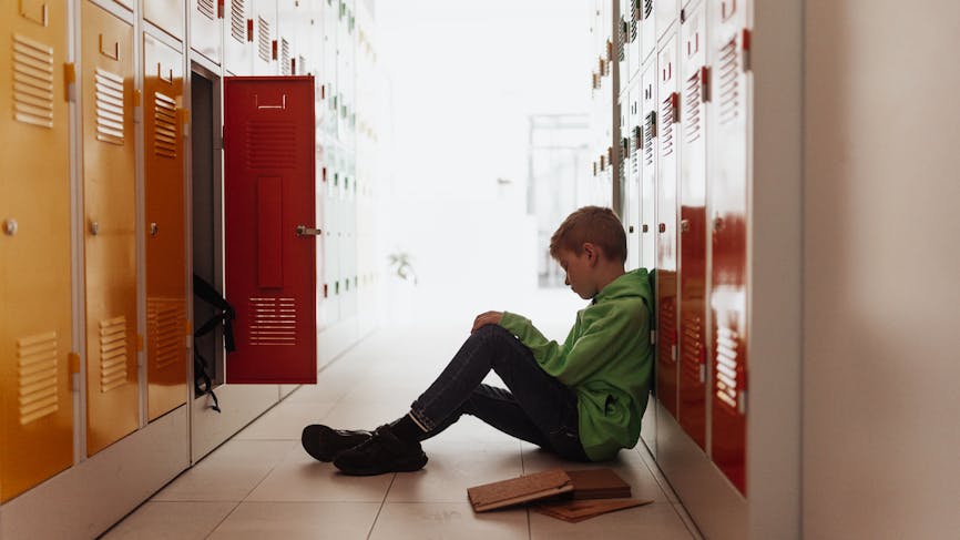 enfant solitaire dans les couloirs d'une école 