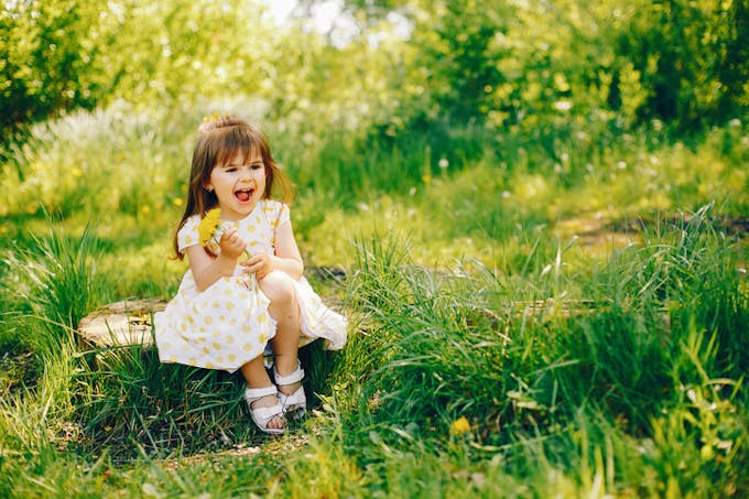 petite fille asise sur l'herbe