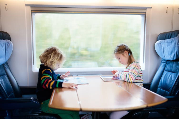 Deux enfants assis dans un train. 